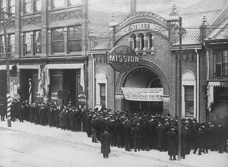 De nombreux hommes attendent devant les portes d’un organisme de charité pour recevoir un repas